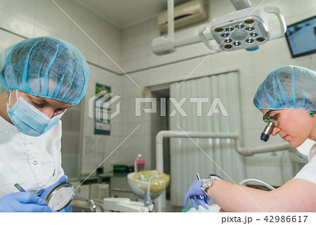 Woman at dentist clinic gets dental treatment to fill a cavity in a tooth. Dental restoration and Woman at dentist clinic gets dental treatment to fill a cavity in a tooth. Dental restoration and 42986617
