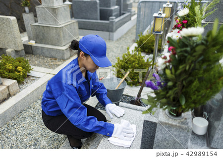お墓掃除をする作業服の女性 42989154