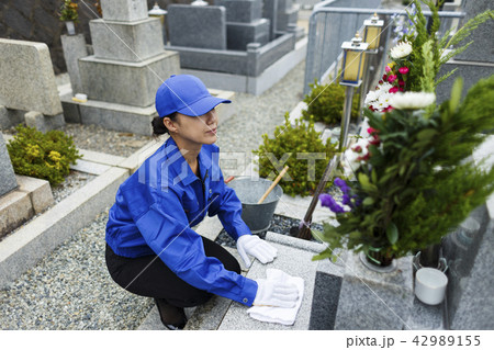 お墓掃除をする作業服の女性 42989155