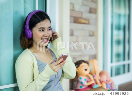Young asian girl enjoy listening to music  42995926