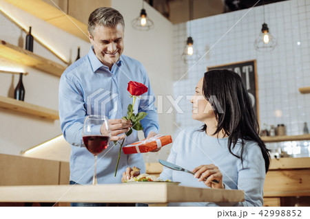 Attractive man presenting a rose to a lady Attractive man presenting a rose to a lady 42998852