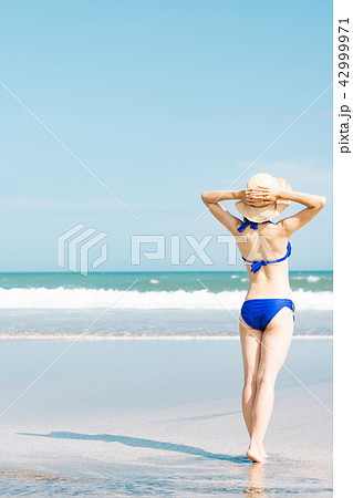 ビーチの水着姿の若い女性 後ろ姿の写真素材