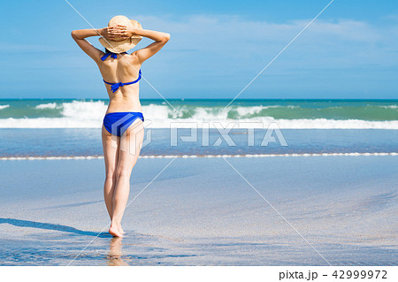 海にいるビキニの若い女性 後ろ姿の写真素材