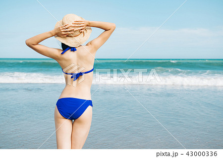 海辺のビキニの若い女性 後ろ姿の写真素材