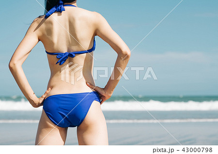 水着の若い女性の後ろ姿 ビーチリゾートの写真素材