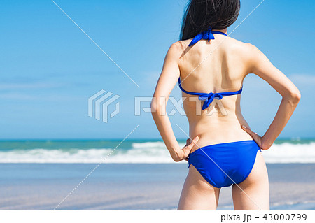 水着の若い女性の後ろ姿 ビーチリゾートの写真素材
