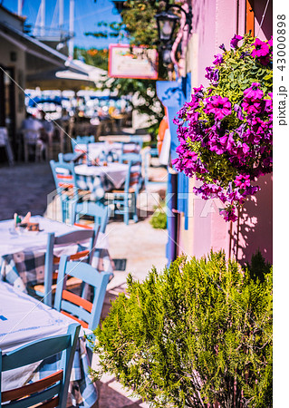 Traditional greek vivid colored tavern on the narrow Mediterranean street on hot summer day 43000898