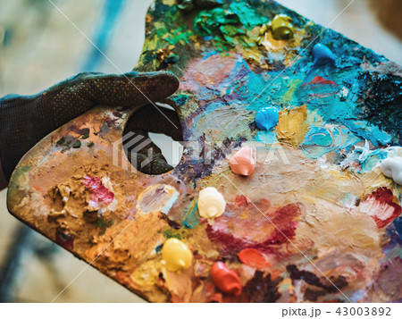 Wooden art palette with oil paints. Mixing colors together. Artistic instrument with many colors 43003892