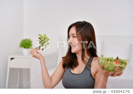 The concept of nutritional food. Beautiful girl takes care of he 43004270