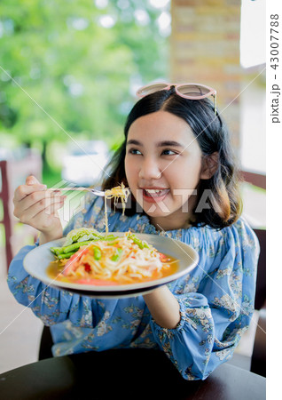 Young asian girl enjoy eating papaya salad Young asian girl enjoy eating papaya salad 43007788