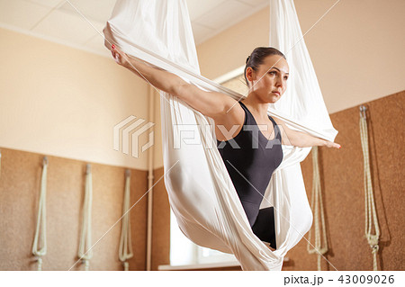 gifted female gymnast with stretched arms doing aerial exercise 43009026