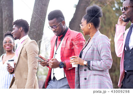 successful boss is looking at the phone while rushing to work with coworkers successful boss is looking at the phone while rushing to work with coworkers 43009298