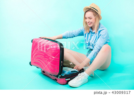young woman opening her suitcase after holidays 43009317