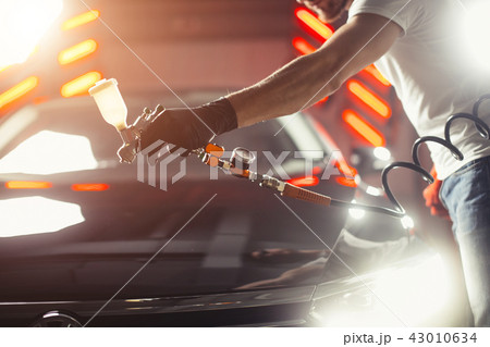 Car wash and coating business with ceramic coating.Spraying varnish to car. Car wash and coating business with ceramic coating.Spraying varnish to car. 43010634