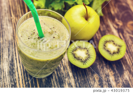 Healthy green smoothie with kiwi, apple on rustic wood background, top view 43019375