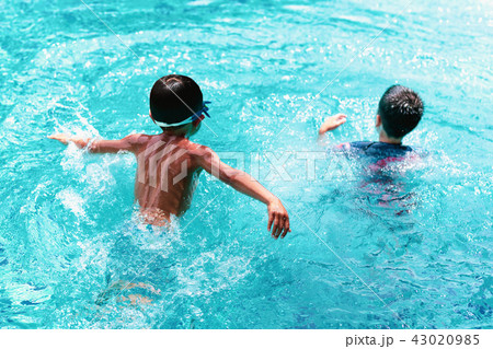Little boy playing in swimming pool with friend 43020985