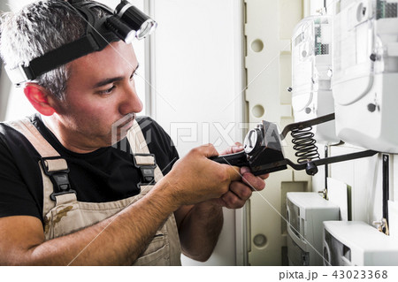 Electrician testing equipment in fuse switch box 43023368