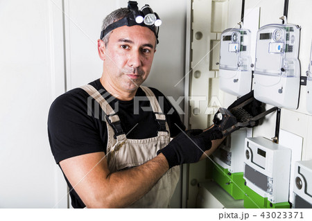 Electrician testing fuse box on head close-up Electrician testing fuse box on head close-up 43023371