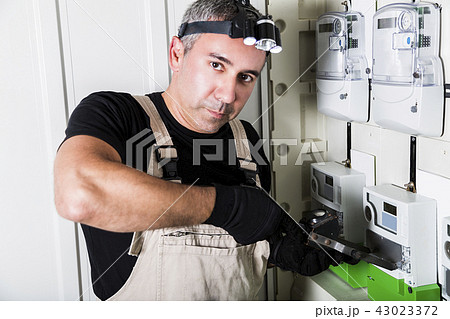 Electrician testing fuse box on head close-up 43023372