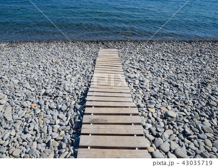 Wooden path to the sea. Flooring of planks on the path to the sea Wooden path to the sea. Flooring of planks on the path to the sea 43035719
