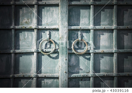 Ancient forged door with a rings 43039116