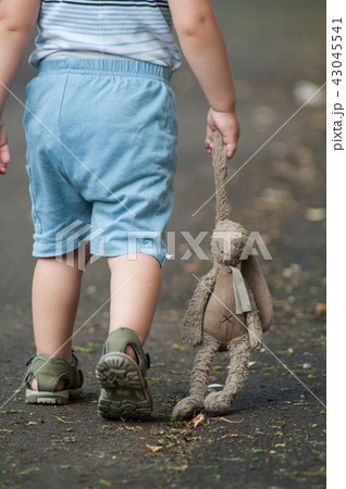 child walking in the street with rabbit in hand 43045541