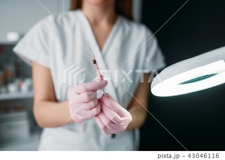 Beautician with syringe in hands, botox injection Beautician with syringe in hands, botox injection 43046116