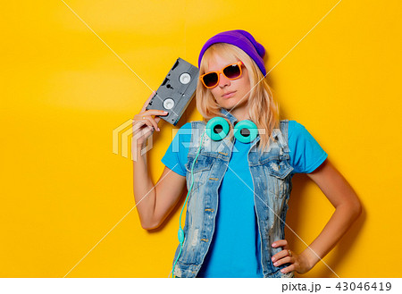 trendy girl in hat with VHS cassette 43046419