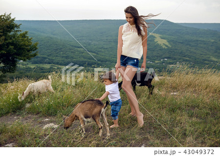 woman with a child in a field on the mountain 43049372