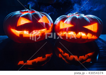 Two different Halloween pumpkins on dark background 43054374