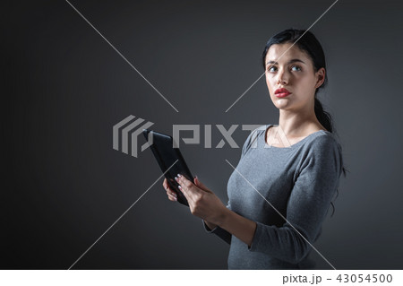 Young woman using her tablet Young woman using her tablet 43054500