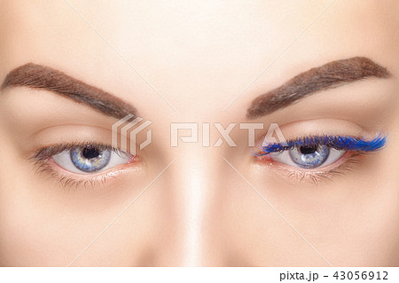 Eyelash Extension Procedure. Woman Eye with Long Blue Eyelashes. Ombre effect. Close up, selective 43056912