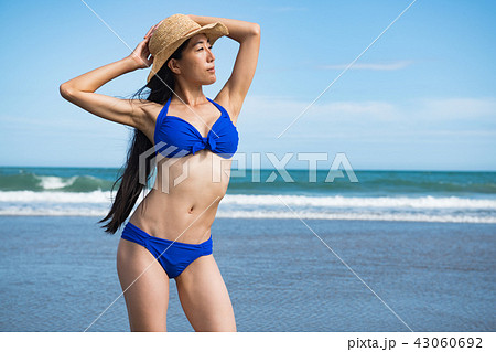 ビーチに立つ青いビキニの若い女性 ビーチに立つ青いビキニの若い女性 43060692