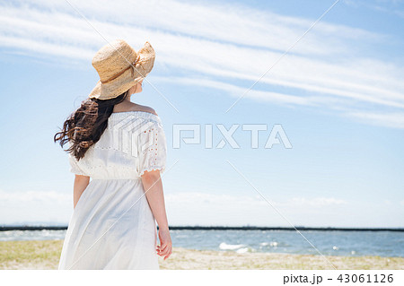 女子旅 白いワンピースの若い女性 後ろ姿の写真素材