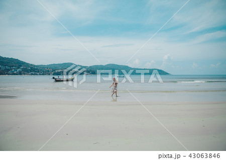 handsome girl on the beach background. Portrait of a woman in white clothes on the sea handsome girl on the beach background. Portrait of a woman in white clothes on the sea 43063846