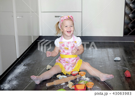 Little girl making dough and cookies in kitchen 43063983