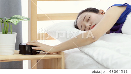 lazy asian woman refusing to wake up lying on her bed 43064511