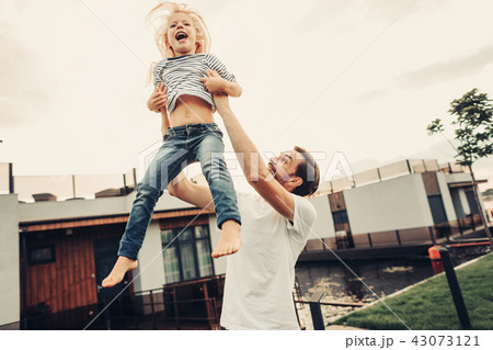 Laughing dad playing with glad daughter outside Laughing dad playing with glad daughter outside 43073121