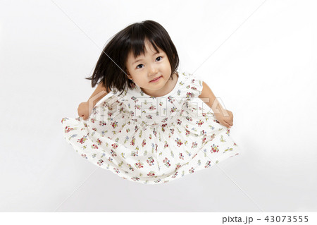 スカートを広げ上を見る幼い女の子の俯瞰の写真素材