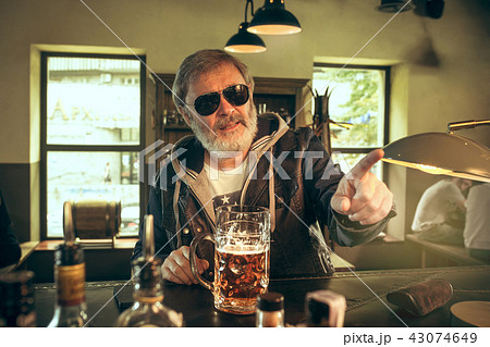 The senior bearded male drinking beer in pub The senior bearded male drinking beer in pub 43074649