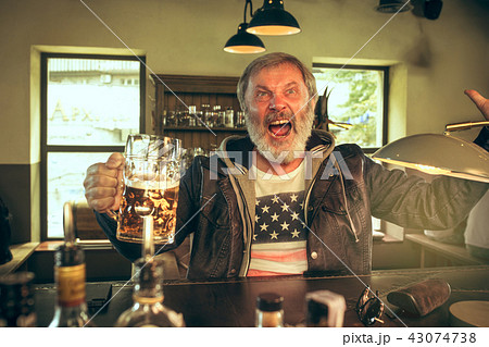 The senior bearded male drinking beer in pub The senior bearded male drinking beer in pub 43074738