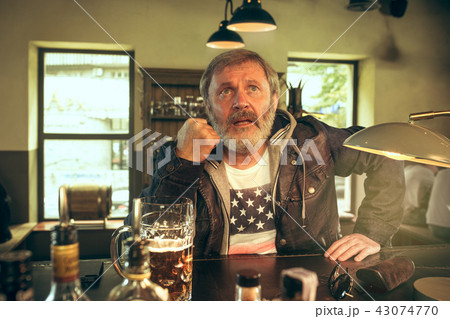 The senior bearded male drinking beer in pub 43074770