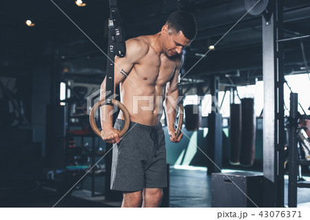 Shapely man is training with gymnastic outfit indoor Shapely man is training with gymnastic outfit indoor 43076371