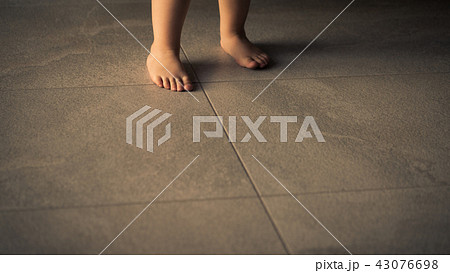 Barefoot baby are staying on heating tile floor. Barefoot baby are staying on heating tile floor. 43076698