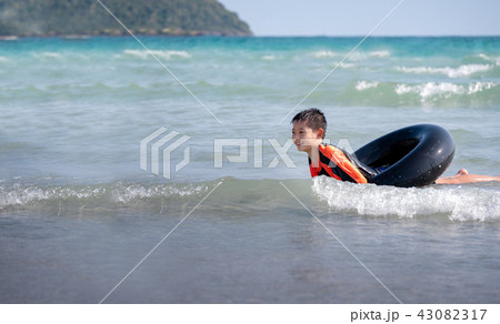 little Asian boy play waves on the beach little Asian boy play waves on the beach 43082317