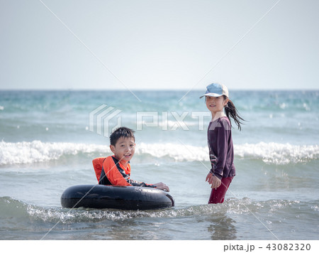 little Asian boy and girl play waves on the beach little Asian boy and girl play waves on the beach 43082320