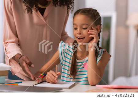Positive joyful girl looking at her copybook 43082321