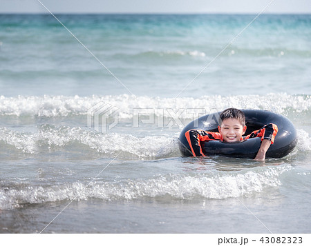 little Asian boy play waves on the beach  43082323