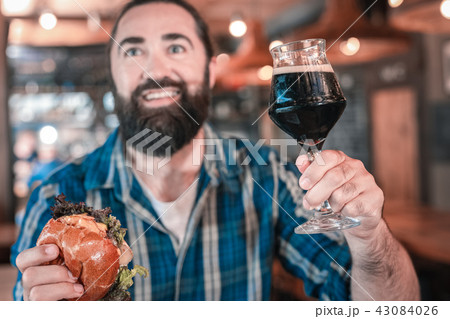 Smiling bearded man saying his toast holding glass of beer 43084026