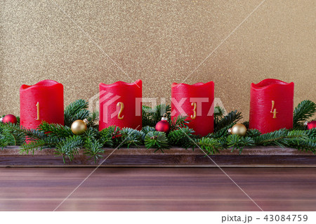 traditional red advent candles with numbers and branch of fir with christmas baubles on gold 43084759
